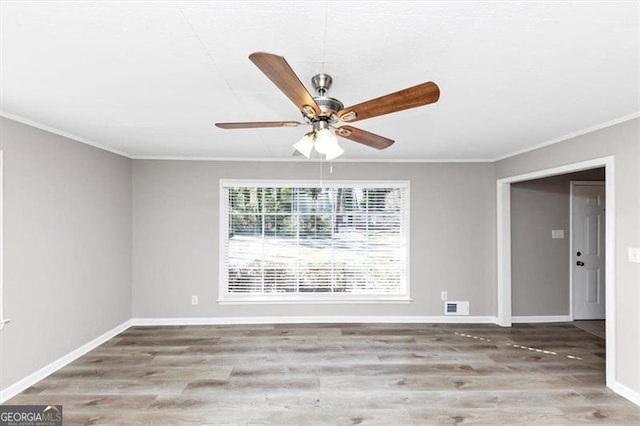 unfurnished room featuring wood finished floors, baseboards, and ornamental molding