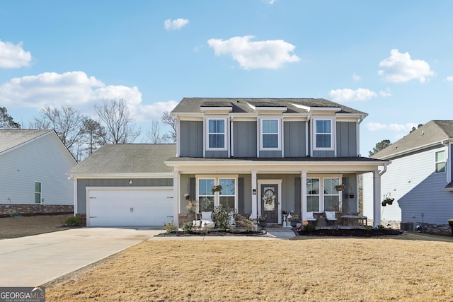 traditional-style home with a front yard, driveway, a porch, an attached garage, and board and batten siding