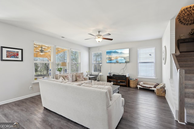 living room with dark wood finished floors, stairway, a wealth of natural light, and ceiling fan