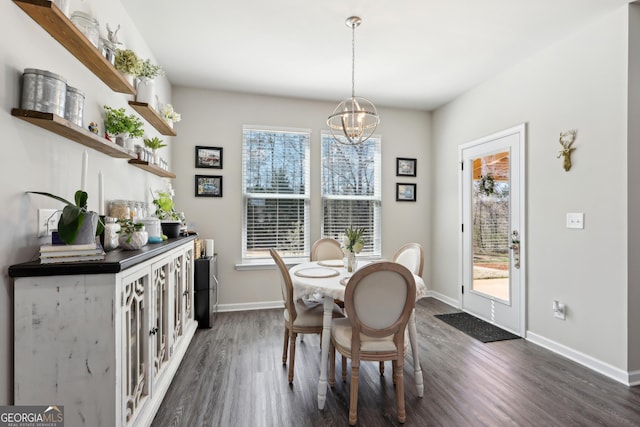 dining space featuring dark wood finished floors, a notable chandelier, a healthy amount of sunlight, and baseboards