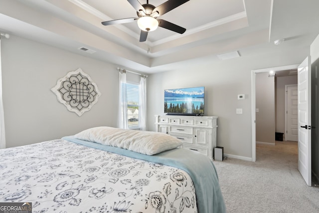 bedroom featuring baseboards, visible vents, a tray ceiling, ceiling fan, and light carpet