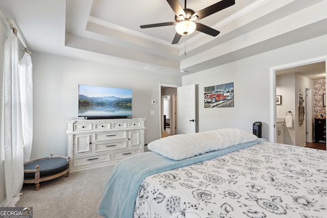 bedroom featuring ornamental molding, a ceiling fan, a tray ceiling, connected bathroom, and carpet