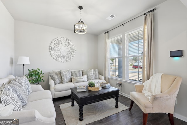 living area featuring visible vents, plenty of natural light, and dark wood-style floors