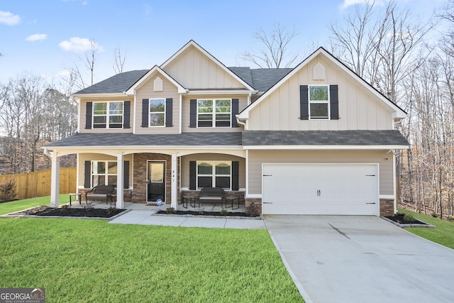 craftsman inspired home featuring board and batten siding, a porch, a front yard, and fence