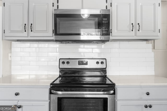 kitchen with light countertops, white cabinets, tasteful backsplash, and stainless steel appliances