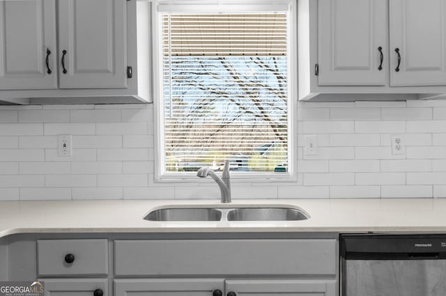 kitchen with a sink, decorative backsplash, dishwasher, and light countertops