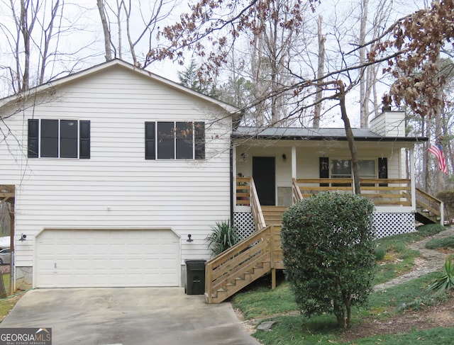 tri-level home featuring stairs, a porch, an attached garage, and concrete driveway