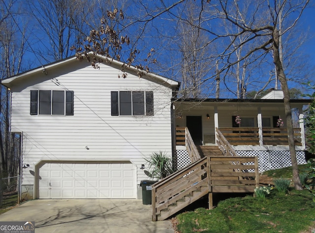 view of front of house with a garage, covered porch, driveway, and stairway