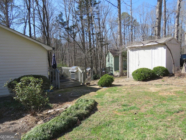 view of yard with a deck, a storage unit, and an outdoor structure