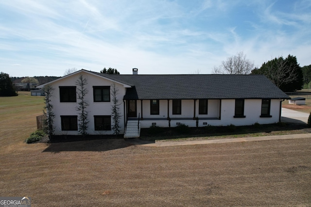 view of front of house with a front lawn and a shingled roof