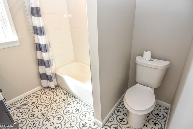 full bath featuring tile patterned flooring, shower / bath combo with shower curtain, toilet, and baseboards