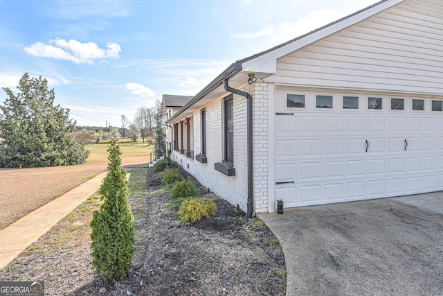 view of property exterior featuring brick siding and a garage