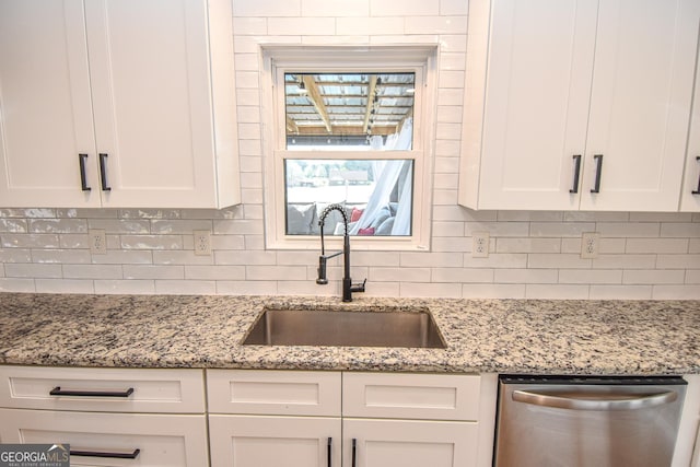 kitchen with a sink, tasteful backsplash, dishwasher, and white cabinetry