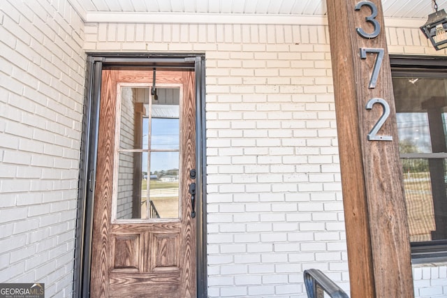 property entrance featuring brick siding