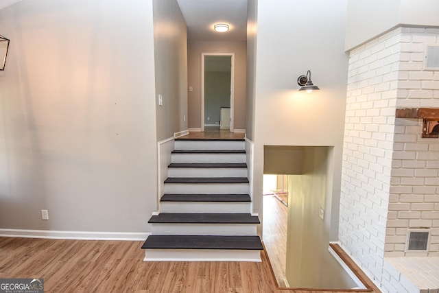 stairway with baseboards and wood finished floors