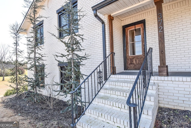 property entrance featuring brick siding