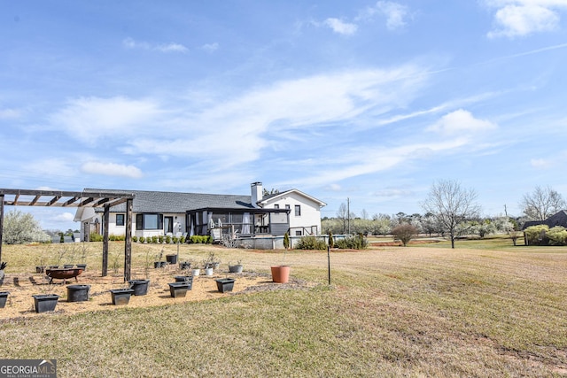 view of yard with an outdoor fire pit and a pergola