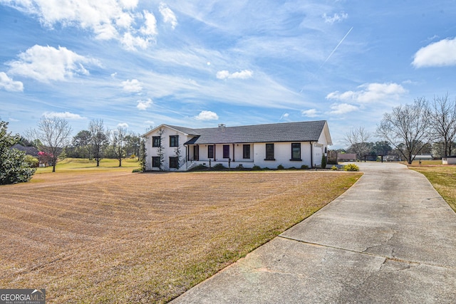 view of front facade with concrete driveway and a front yard