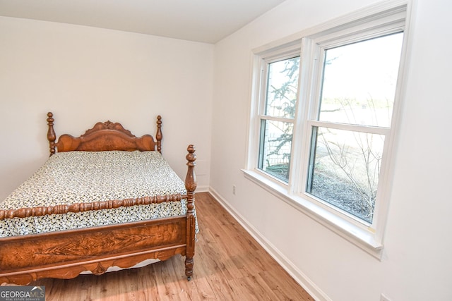 bedroom with baseboards and light wood finished floors