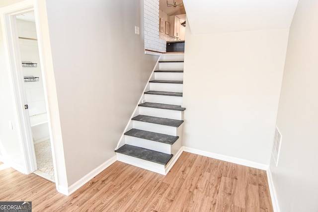 stairway with wood finished floors and baseboards