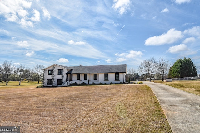 view of front of property featuring concrete driveway and a front yard