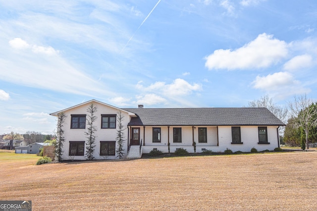 tri-level home with a front lawn and a shingled roof