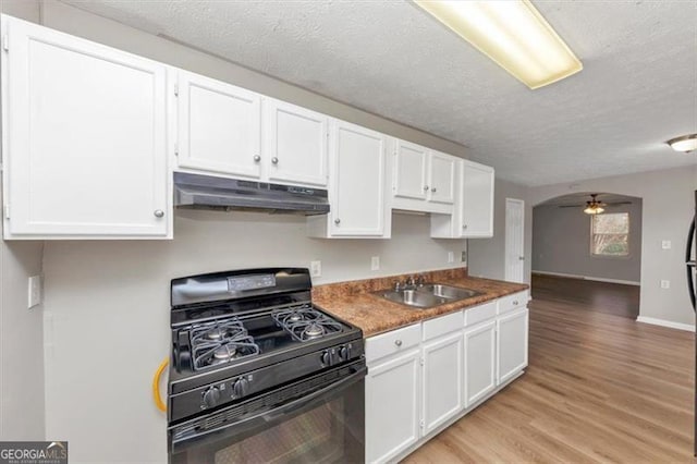 kitchen featuring under cabinet range hood, white cabinets, black range with gas stovetop, and a sink