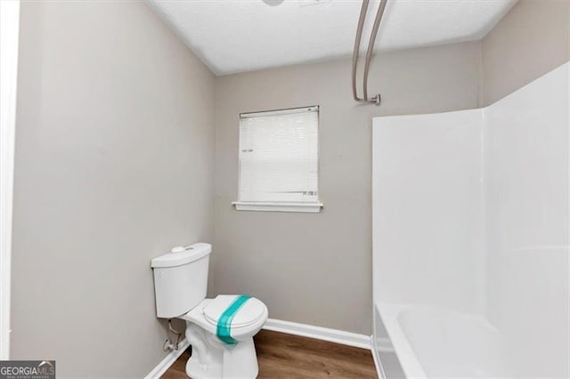 bathroom featuring baseboards, toilet, and wood finished floors