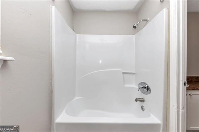 full bath with bathtub / shower combination and a textured ceiling