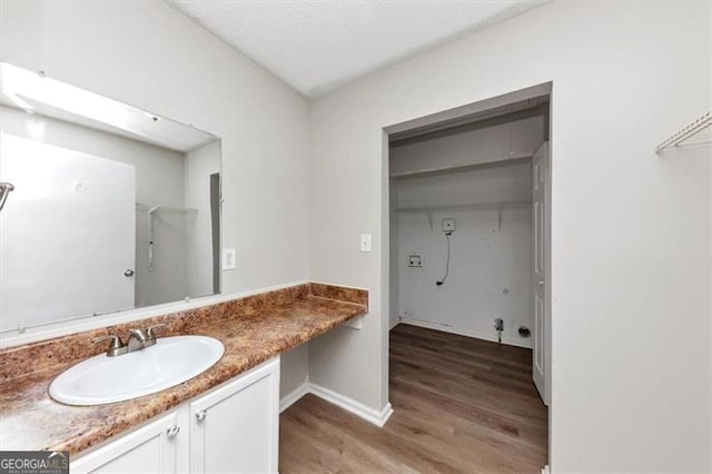 bathroom with baseboards, wood finished floors, and vanity
