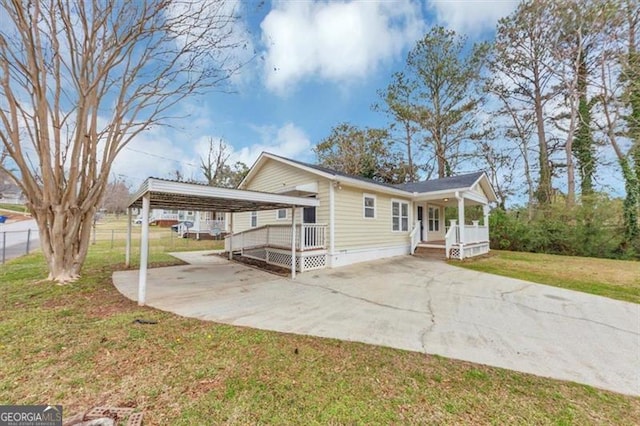 exterior space with covered porch, concrete driveway, a front yard, and fence