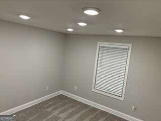 unfurnished room with dark wood-style floors, recessed lighting, and baseboards