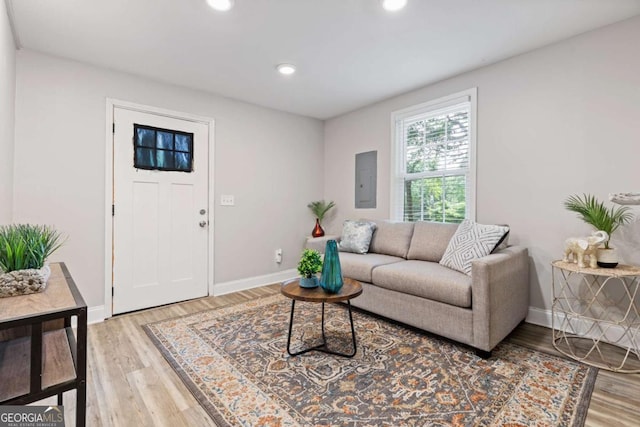 living area with light wood-style flooring, electric panel, recessed lighting, and baseboards