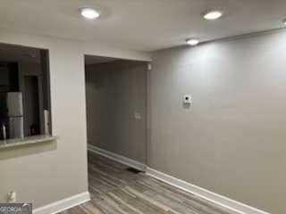 empty room with recessed lighting, wood finished floors, and baseboards