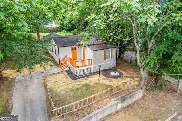 view of front of home featuring a shingled roof and fence