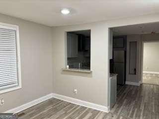 empty room featuring dark wood finished floors and baseboards