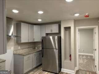 kitchen featuring recessed lighting, baseboards, light countertops, and freestanding refrigerator