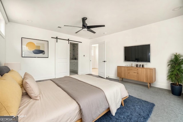 carpeted bedroom featuring a ceiling fan, baseboards, visible vents, a barn door, and connected bathroom