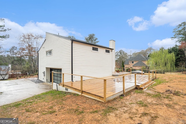 view of outbuilding with driveway, an attached garage, and fence