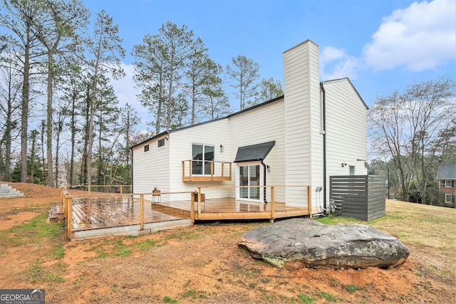 rear view of house with a deck and a chimney