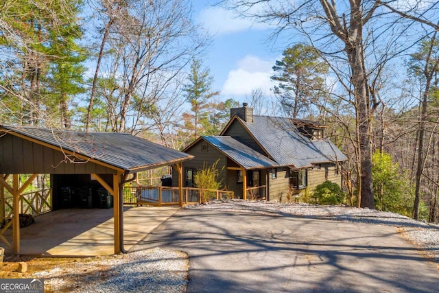 rustic home with driveway and a chimney