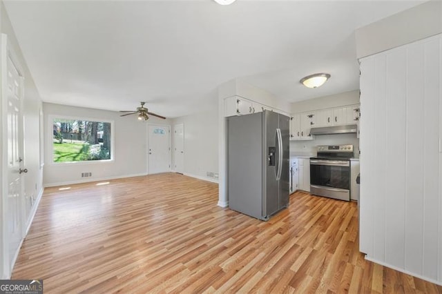 kitchen with light wood finished floors, ceiling fan, stainless steel appliances, under cabinet range hood, and white cabinetry