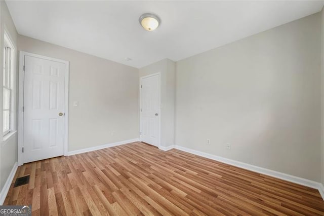 unfurnished bedroom with baseboards, visible vents, and light wood finished floors