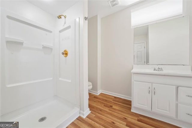 full bathroom featuring vanity, a shower stall, toilet, and visible vents