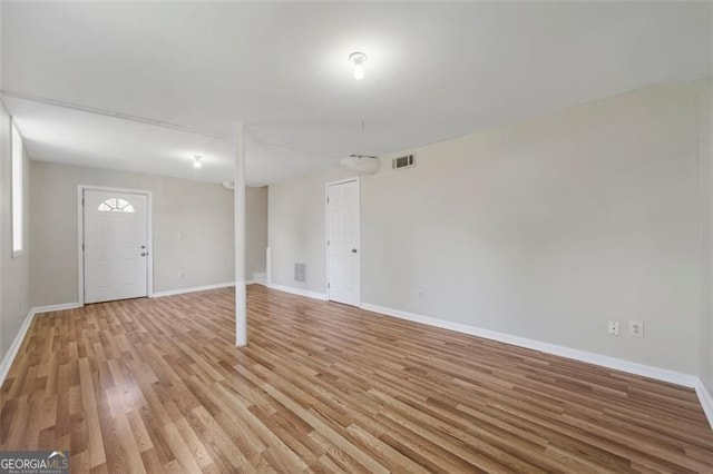 finished below grade area featuring light wood-style floors, visible vents, and baseboards