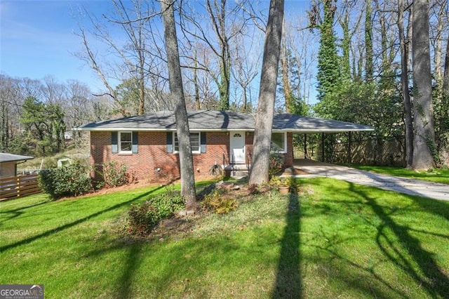 view of front facade featuring a front lawn, an attached carport, fence, concrete driveway, and brick siding