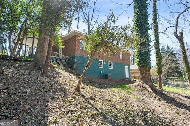 view of side of home featuring central AC and fence