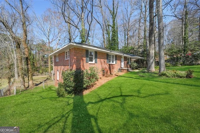 view of side of property featuring brick siding and a lawn