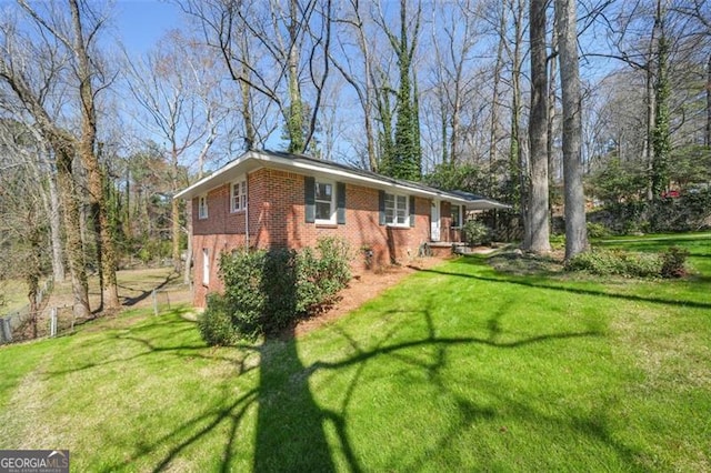 view of side of home with a yard and brick siding