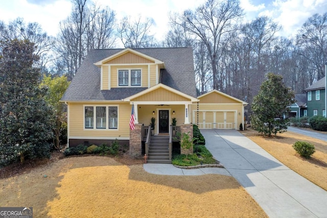 craftsman-style home with covered porch, roof with shingles, concrete driveway, and an attached garage